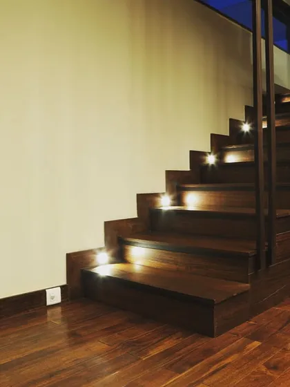 The staircase at the Overseas Traders office features integrated step lighting. This not only enhances safety but also adds a warm, ambient glow, highlighting the beauty of the wooden treads.