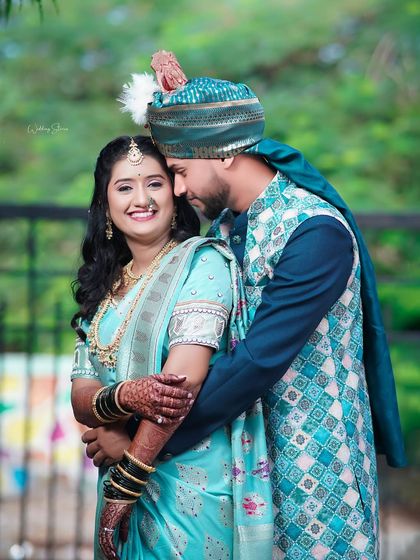 A loving embrace captured in a candid moment. This photo showcases the couple's chemistry and the intricate details of their wedding outfits, from the bride's saree to the groom's turban.