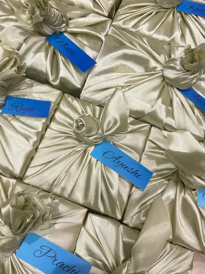 Elegance in every fold. We used a beautiful furoshiki style fabric wrap for these bridesmaid gifts, finished with a personalized name tag for a sustainable and sophisticated presentation.