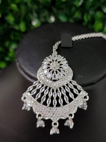 A large, fan-shaped American Diamond maang tikka for a truly glamorous statement.