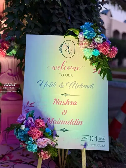 A personalized welcome sign for the Haldi and Mehendi, adorned with beautiful pastel flowers.