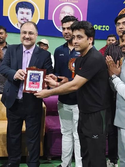 Head Coach Ravindra Singh receiving a plaque in recognition of his performance and victory at the Agra Badminton Premier League. We are proud to have such accomplished leaders guiding our students.