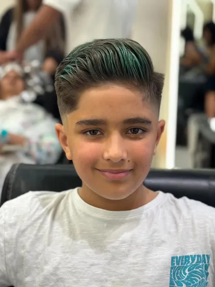 This young client is all smiles with his new haircut and cool green hair color, showing that style has no age limit.
