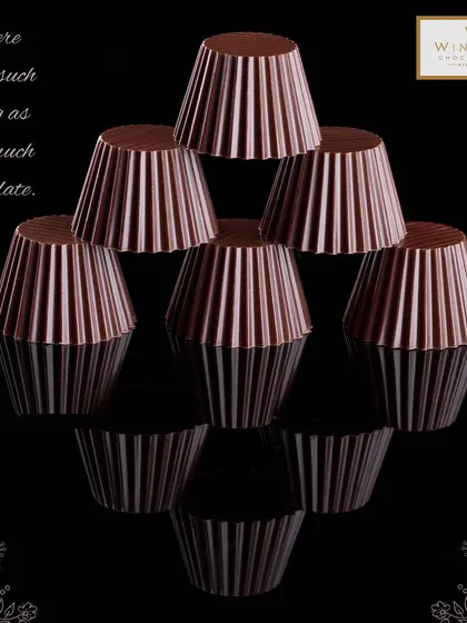 A creative shot of my fluted dark chocolate cups, perfect for filling with ganache or mousse. This demonstrates the versatility of my chocolate components for bakers and pastry chefs.