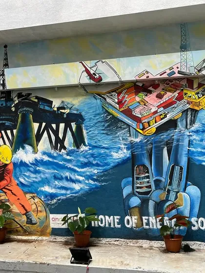The completed ONGC industrial mural, integrated with live plants to soften the space.