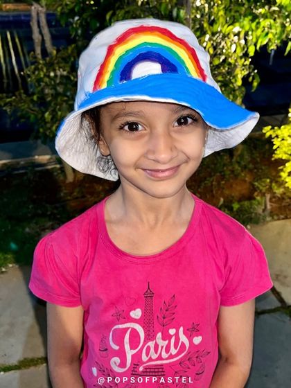 The smile of a proud creator. This girl loves the rainbow hat she designed and painted.