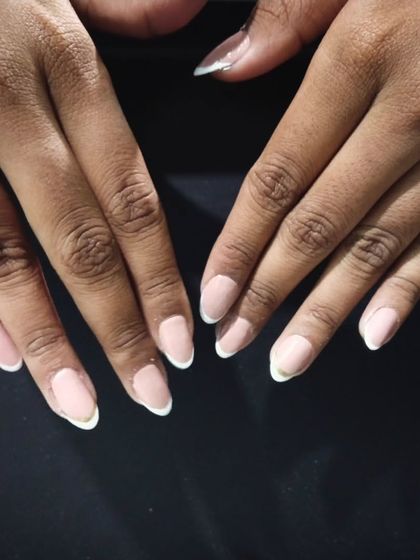 A simple and clean French manicure on shorter, natural nails. This shows that you don't need long extensions to enjoy this classic style. It's perfect for a low-maintenance, professional look.