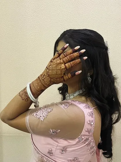 A shy and happy moment, with the beautiful mehendi taking center stage.