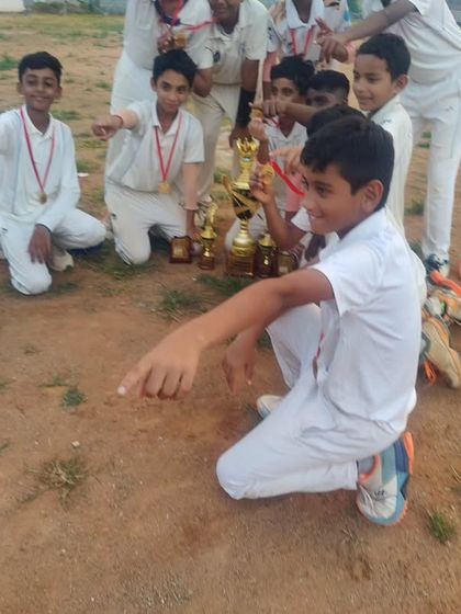 Our young champions pointing to their trophies. This photo captures the pride and excitement of winning a major U-12 tournament.