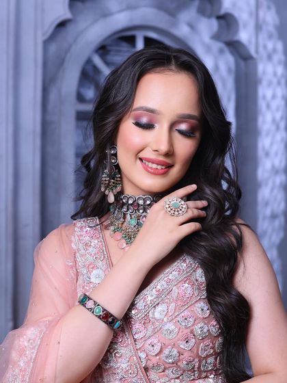 A serene and beautiful close-up. The soft lighting highlights the glowing skin and the intricate details of the eye makeup.