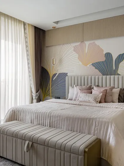 This daughter's bedroom is designed to be effortlessly poised. A custom wallpaper with an oversized botanical pattern provides a beautiful backdrop for the bed, which features a fluted headboard and soft blush bedding.