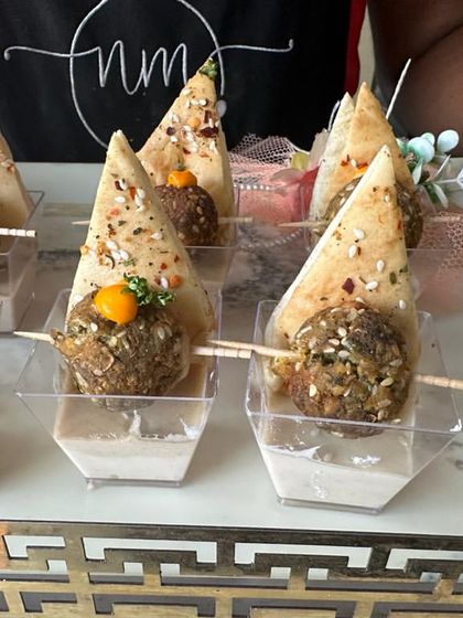 A classic Lebanese starter. This tray holds individual portions of falafel and pita, served with a side of creamy hummus, making for a perfect bite-sized appetizer.