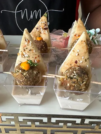 A classic Lebanese starter. This tray holds individual portions of falafel and pita, served with a side of creamy hummus, making for a perfect bite-sized appetizer.