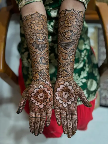 The bride showing off her beautiful, personalized mehendi. The combination of the palm mandalas and the floral arm design is just perfect.
