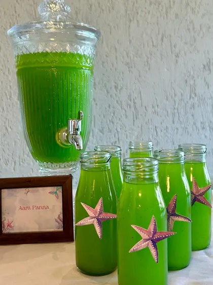 Refreshing Aam Panna served in cute, starfish-adorned bottles for a mermaid-themed 3rd birthday party.