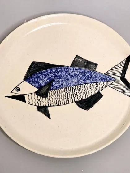 This sold plate features a stylized fish with geometric patterns. It was designed as a perfect wall decoration or a thoughtful housewarming gift.