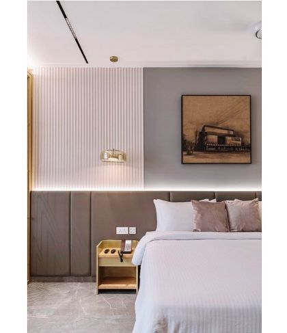 Details matter in creating a sense of luxury. This close-up of the hotel bedroom shows the interplay of textures, from the vertically ribbed wall panels to the soft upholstery and the warm glow of the integrated bedside lighting.