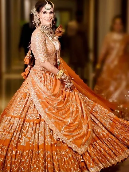Our client looking absolutely regal in a burnt orange lehenga with rich gota pati embroidery. The twirling motion shows off the beautiful flare of the skirt.