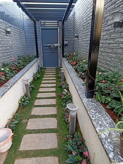 This narrow side passage was transformed into a beautiful garden path. I used stone pavers for the walkway and filled the raised beds with colorful anthuriums and other shade-loving plants.