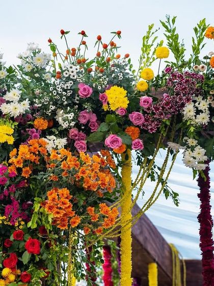 Another detail shot of the lush, colorful flowers adorning the wooden mandap structure.