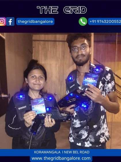 Two players proudly show off their laser tag score cards after a competitive game.