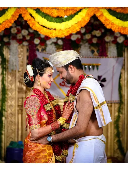 An intimate portrait of the bride and groom at the mandap. Their traditional attire, the floral decorations, and their connection create a beautiful wedding photograph.