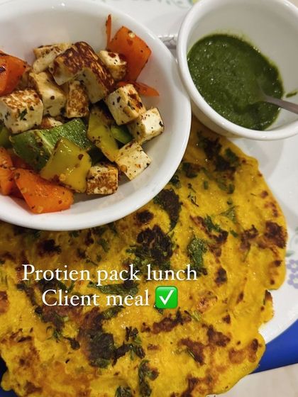 A protein-packed lunch of besan cheela with a side of sautéed paneer and vegetables, and green chutney.
