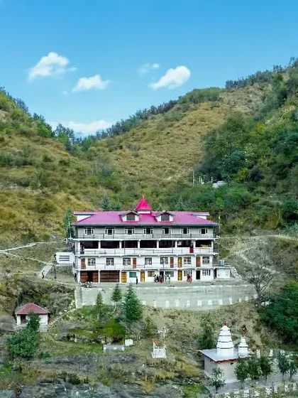 A wide landscape view showing the Bhuteshwar Maharaj Maipul Temple and its surroundings. This helps establish the location and shows how the temple sits within the valley.