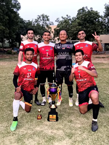 The team posing with the Champions Cup trophy after another successful tournament.