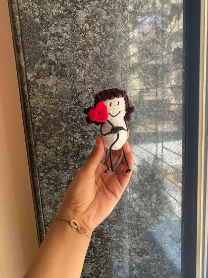A simple and sweet message doll. This little figure holds a bright red heart, a perfect way to send a little bit of love to someone you care about.