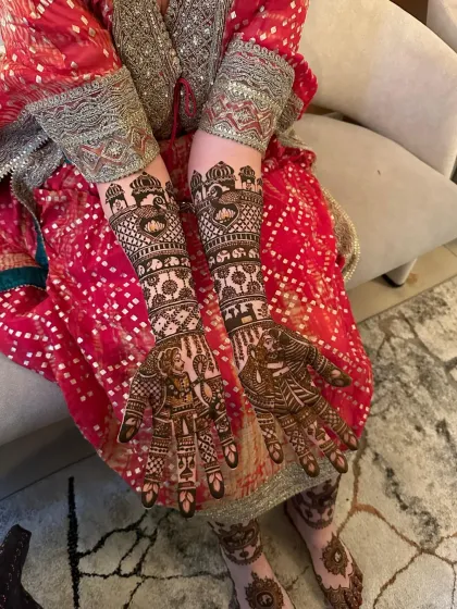 A close-up of the bride's hands and feet, showing the continuity of the design. This set features portraits and traditional Rajasthani architectural elements.