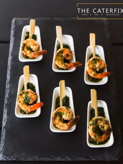 These are my pesto-marinated grilled prawns, served on a bed of green chutney. I focus on fresh ingredients and beautiful presentation to create appetisers that are as visually appealing as they are delicious.