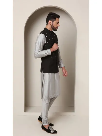 A side profile of the Shoorveer bandi set, highlighting the sharp contrast between the black vest and the shimmering grey kurta.