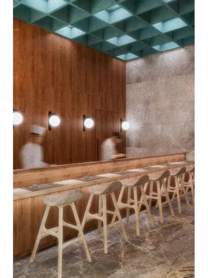 The sushi bar at CHAMPON, offering a direct view of the chefs at work. The design here is clean and functional, with a coffered ceiling and simple wood counter that honor the precision of Japanese culinary arts.
