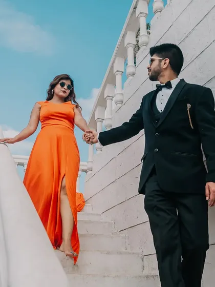 Sometimes, elegance is in the simplicity. This couple chose a vibrant orange gown with a tasteful side slit and a subtle trail for their pre-wedding shoot, creating a look that is both stylish and timeless.
