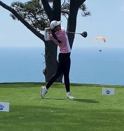 One of our students, Mahreen Bhatia, executes a powerful drive at the iconic Torrey Pines South Course during the Junior World Golf Championships. This action shot captures the focus and skill honed at our academy.