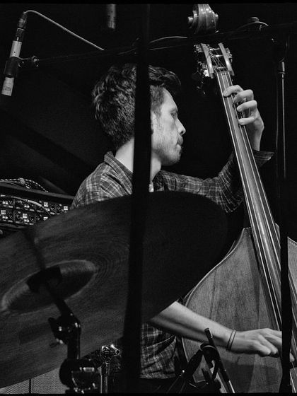 A duplicate of image 40, a black and white shot of our bassist at the Nublu concert. The focus is entirely on him and his instrument, highlighting his incredible skill.
