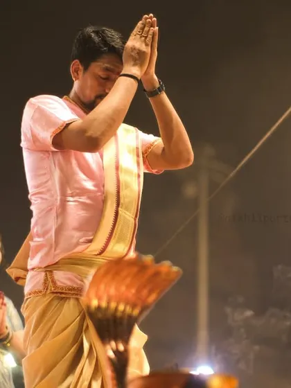 A priest in a moment of prayer during the Ganga Aarti. This image captures the deep faith and reverence that is at the heart of these ancient rituals.