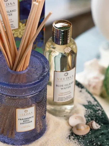 Elevate your senses with our Blue Island Water essential oil reed diffuser. This beach-themed shot, complete with sand and seashells, perfectly captures the fresh, aquatic nature of this popular summer fragrance.