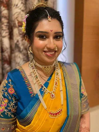 A full view of this stunning bride's wedding look, featuring a vibrant blue and yellow saree and traditional jewelry.