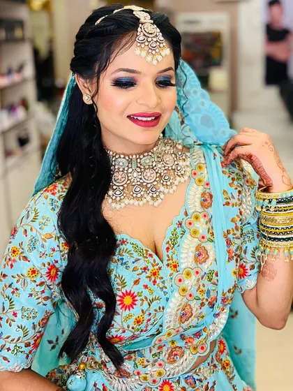 The client is all smiles, showing off her complete look. The bold eye makeup is balanced with a softer lip color for a harmonious finish.