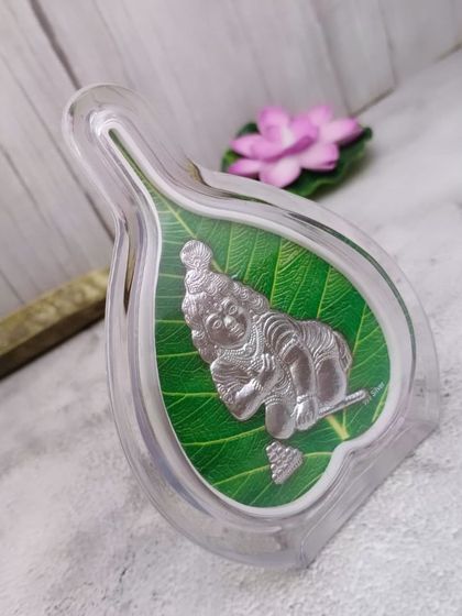 A Ganesha idol made of 999 pure silver, encased in a leaf-shaped acrylic frame. This is a newly added exclusive piece for modern gifting.