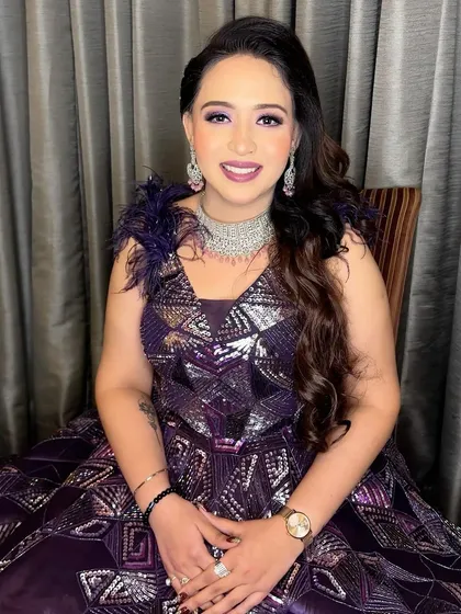 The smile of a bride-to-be. Her glamorous purple gown is paired with equally glamorous makeup, featuring a shimmery eye and a radiant complexion.
