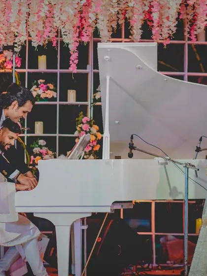 A sweet moment during the reception where the groom is learning to play the piano for his bride. We help incorporate such personal touches into your celebration.