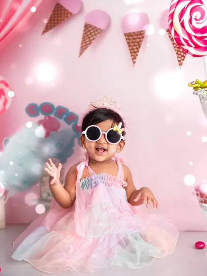 Striking a pose with her cool sunglasses, this little girl is the star of her first birthday party. Our themed cake smash sessions include fun accessories to match your child's personality.