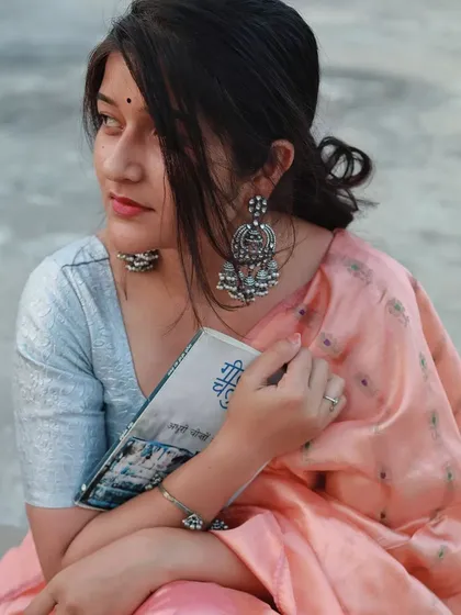 We created this thoughtful portrait session around a love for books and quiet moments. Dressed in a beautiful saree with traditional jewelry, she holds a book with Hindi script, creating a narrative that feels both classic and deeply personal.