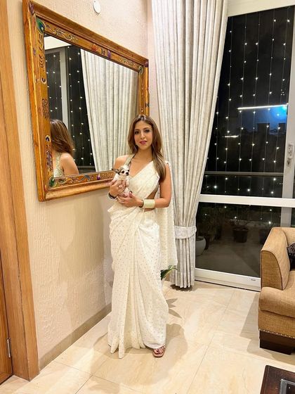 Dressed in a white saree for Diwali, holding my little one. Festive occasions are all about family and traditions.
