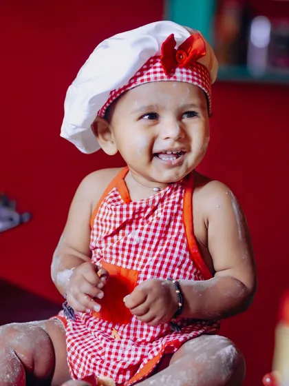 A little chef in the making! This creative cake smash theme features a baby in a chef's hat and apron, enjoying the messy fun.