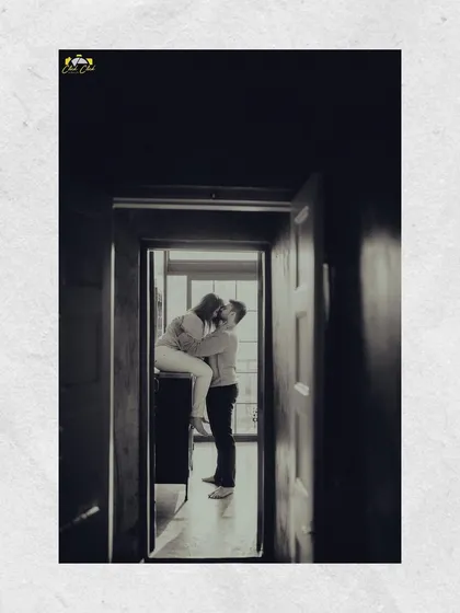 A black and white shot from a doorway, creating a beautiful, intimate frame for the couple's kiss. This image is from the same series as the creative dry ice shoot, showing variety within a single session.