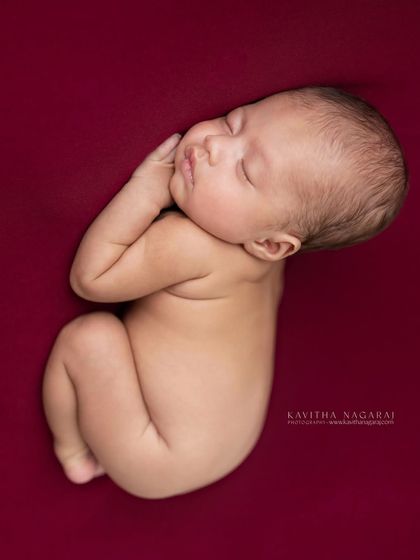 A classic black and white portrait of a newborn curled up on their side. Stripping away the color allows the focus to be entirely on their form and peacefulness.